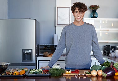 Hombre en cocina con diferentes alimentos, quitar mal olor del refrigerador